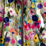 Quilted floral jacket detail with multicolor buttons and cream stand collar.