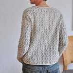 Speckled knit sweater with ribbed crew neck, long sleeves, and textured pattern