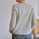 Speckled knit sweater with ribbed crew neck, long sleeves, and textured pattern