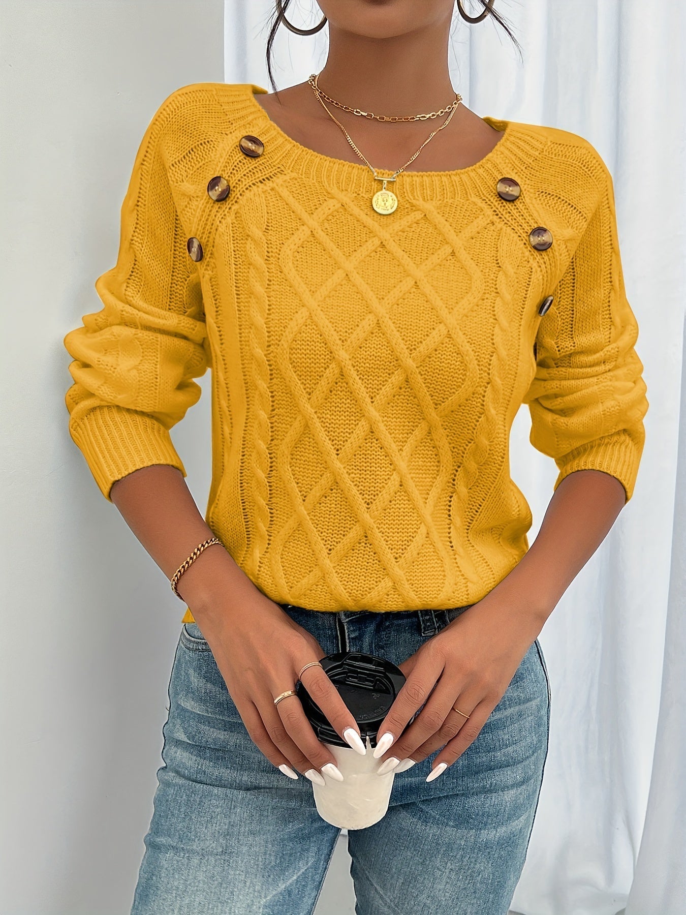 Mustard yellow cable-knit crewneck sweater with decorative shoulder buttons and ribbed cuffs
