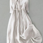 White button-front tie-waist dress with 3/4 sleeves and gathered skirt.