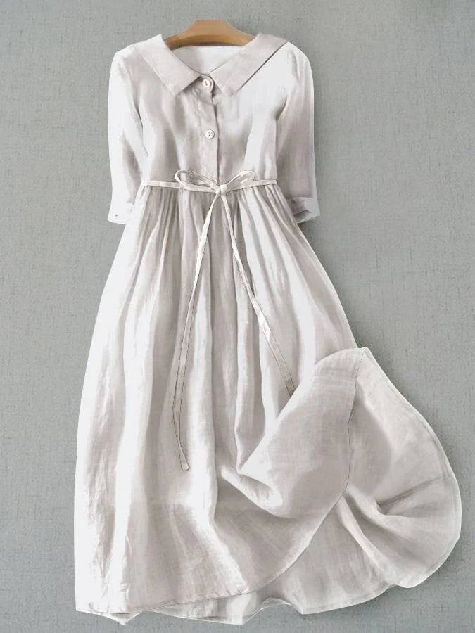White button-front tie-waist dress with 3/4 sleeves and gathered skirt.