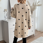 Back view of beige knit cardigan with allover black heart print and long sleeves