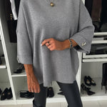Gray knit pullover with round neckline and buttoned sleeve cuffs
