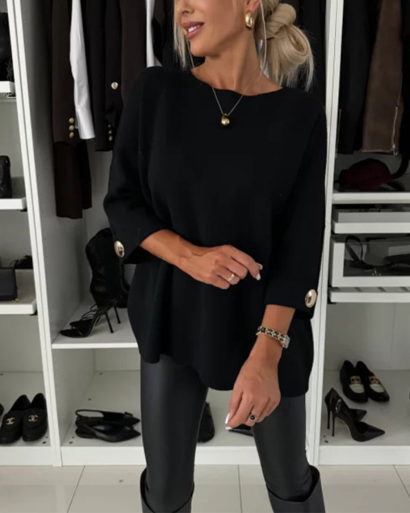 Black long-sleeve knit pullover with round neckline and buttoned cuffs
