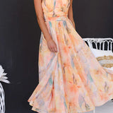 Peach watercolor halter maxi dress with sleeveless high neckline and full skirt