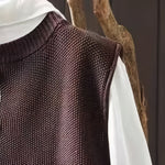Brown knit cardigan fabric close-up with subtle texture and ribbed shoulder yoke
