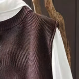 Brown knit cardigan fabric close-up with subtle texture and ribbed shoulder yoke