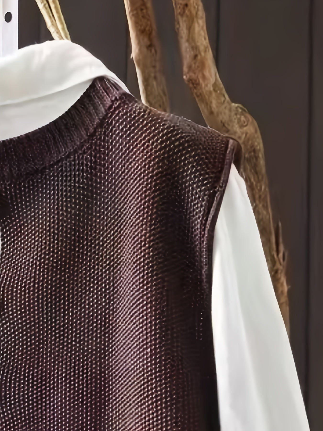 Brown knit cardigan fabric close-up with subtle texture and ribbed shoulder yoke