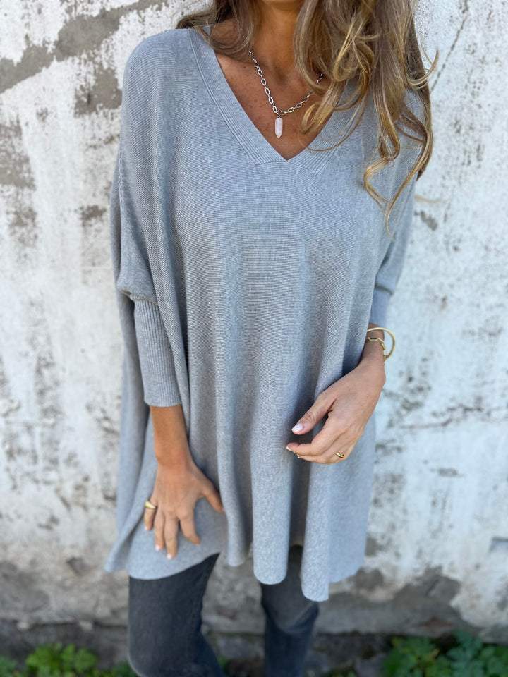 Light blue V-neck pullover sweater with wide sleeves and relaxed hem.