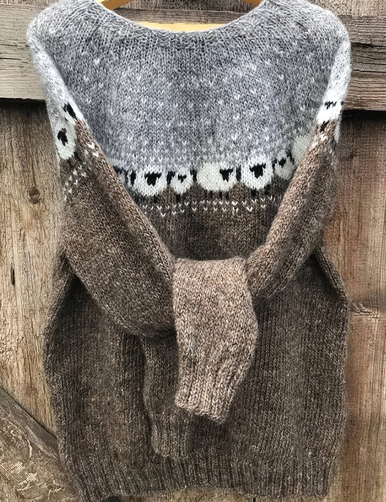 Gray knit pullover sweater with brown cuffs and white/black animal fair isle pattern