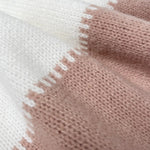 Knit close-up of pullover: cream and blush-pink panel with textured border