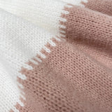 Knit close-up of pullover: cream and blush-pink panel with textured border