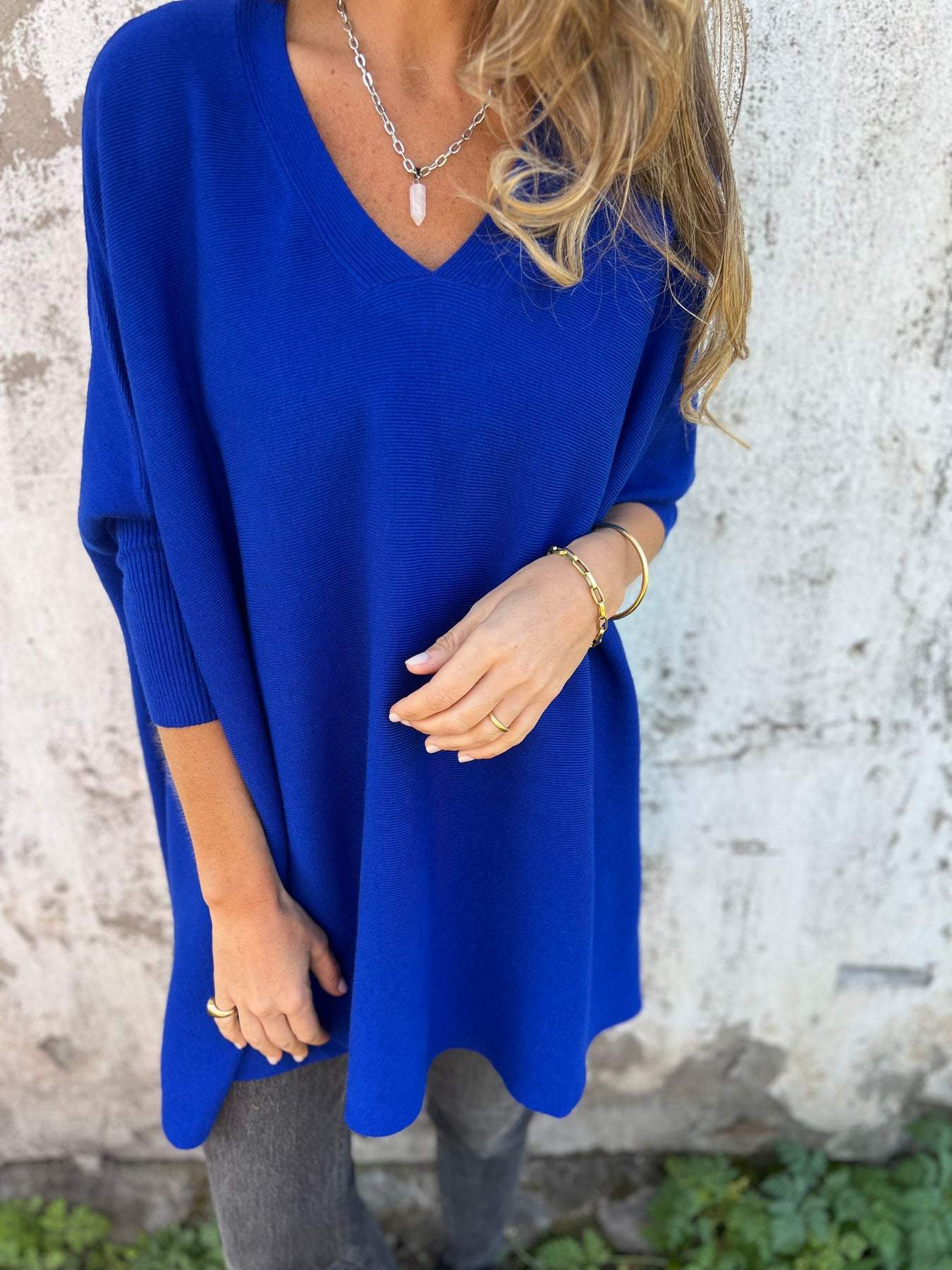 Royal blue V-neck pullover sweater with three-quarter sleeves and side split hem.