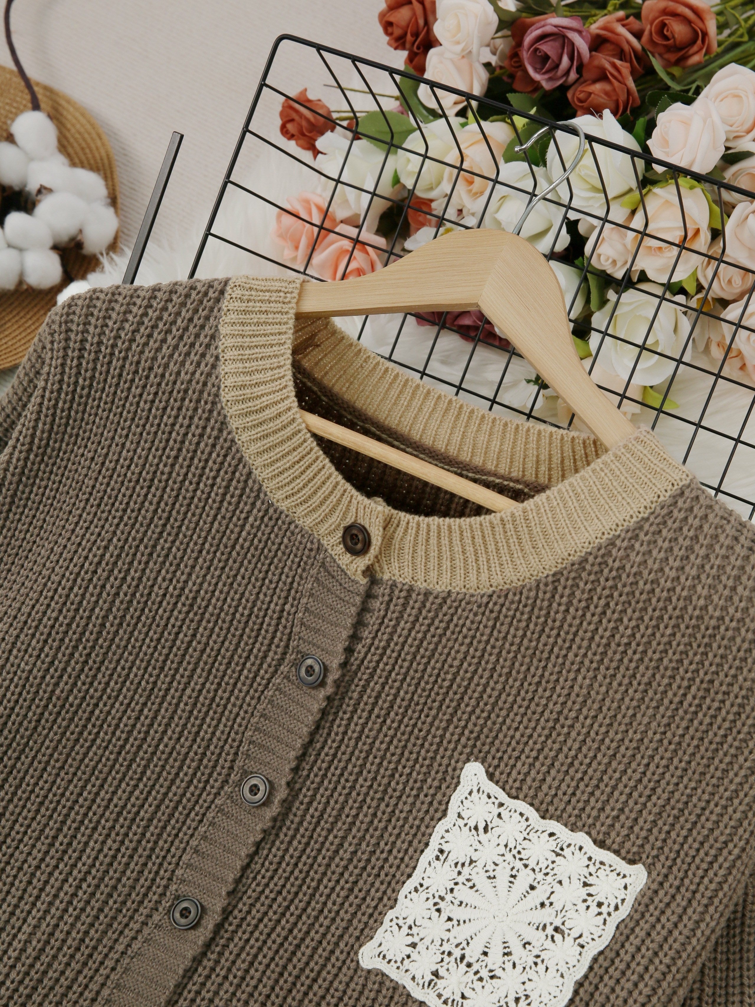 Close-up dark brown knit cardigan with button placket and crocheted square chest patch