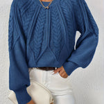 Blue cable-knit long-sleeve pullover with half-zip neckline and ribbed cuffs