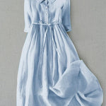 Light blue button-front tie-waist dress with 3/4 sleeves and gathered skirt.