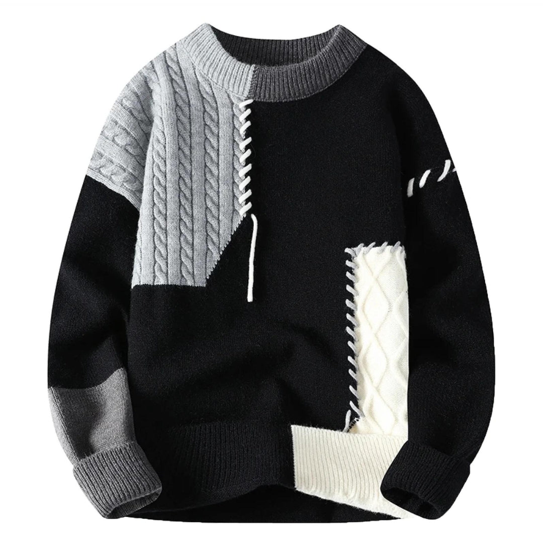 Black knit sweater with cream accents and light gray cable panel; ribbed crew neck