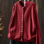 Red knit cardigan with round neckline, button-front placket and long sleeves.