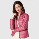 Pink quilted puffer jacket with zip front and stand collar, model posing