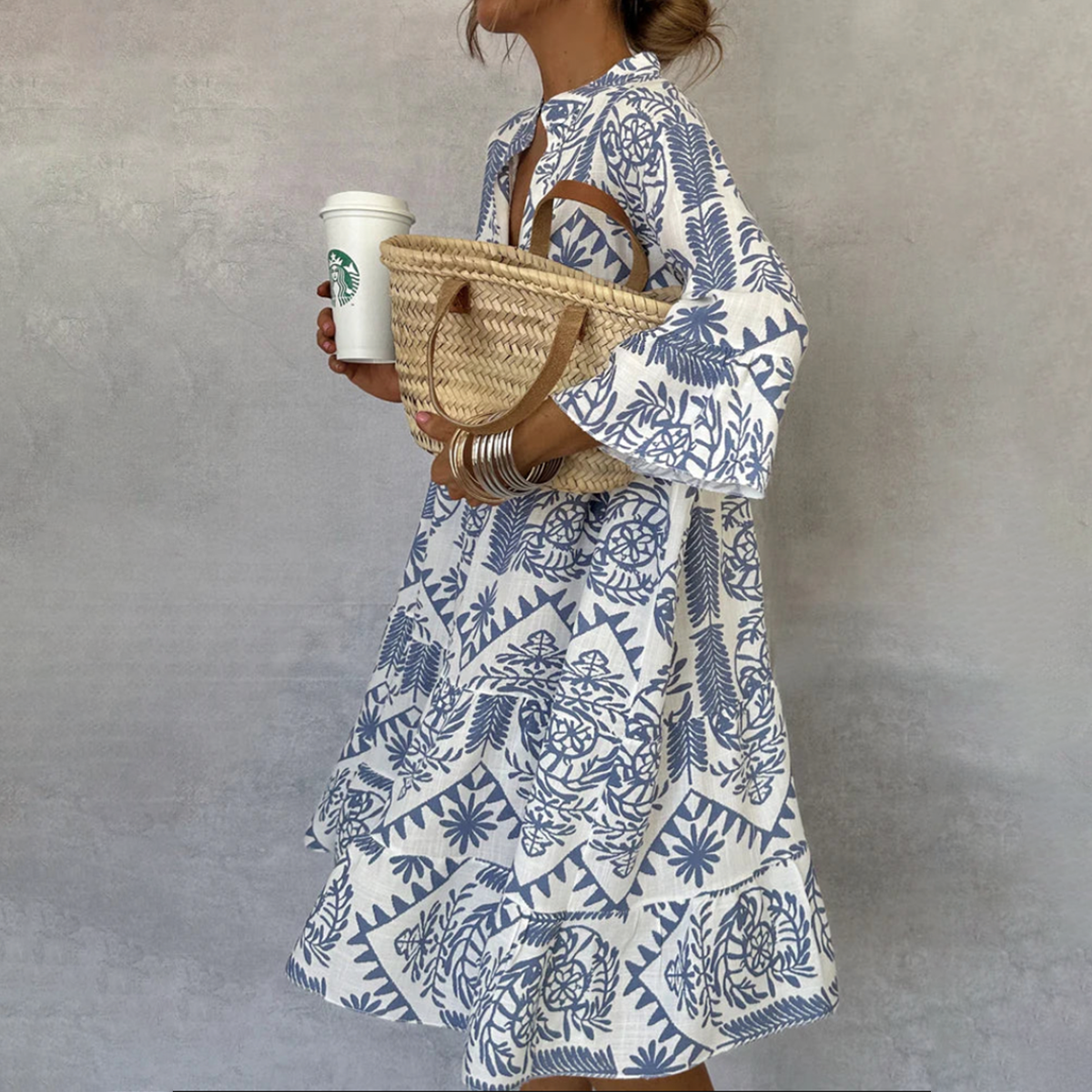 Blue-and-white patterned V-neck mini dress with long sleeves and flared skirt.