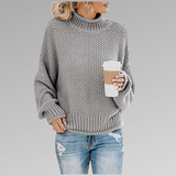 Light gray chunky knit sweater with ribbed turtleneck, long sleeves, and straight hem