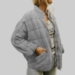 Gray quilted oversize step jacket with zip front, stand collar, and side pockets