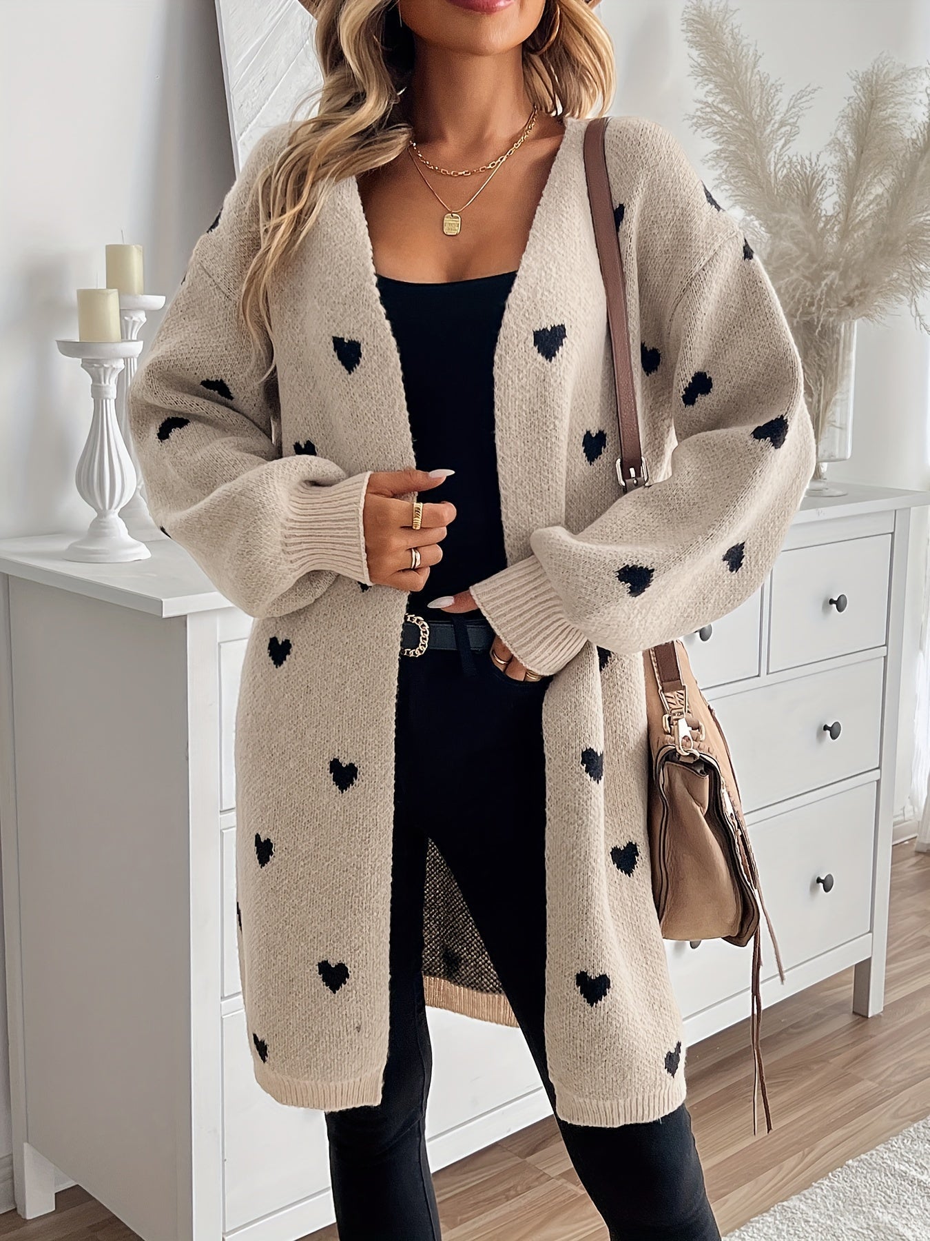 Heart-pattern knit cardigan with open front, long sleeves, light beige knit with dark hearts.