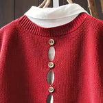 Red knit sleeveless cardigan close-up with cowl neck and gold-tone button row