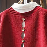 Red knit sleeveless cardigan close-up with cowl neck and gold-tone button row