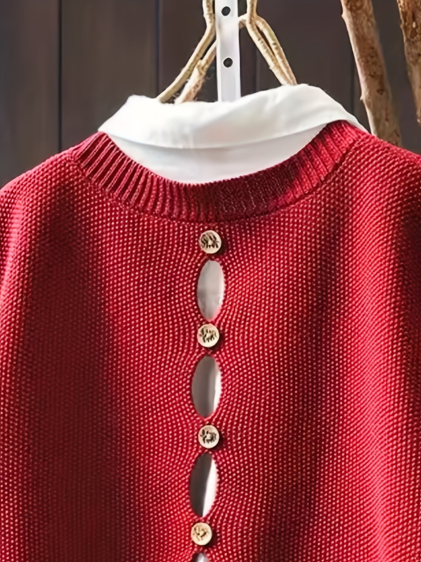 Red knit sleeveless cardigan close-up with cowl neck and gold-tone button row