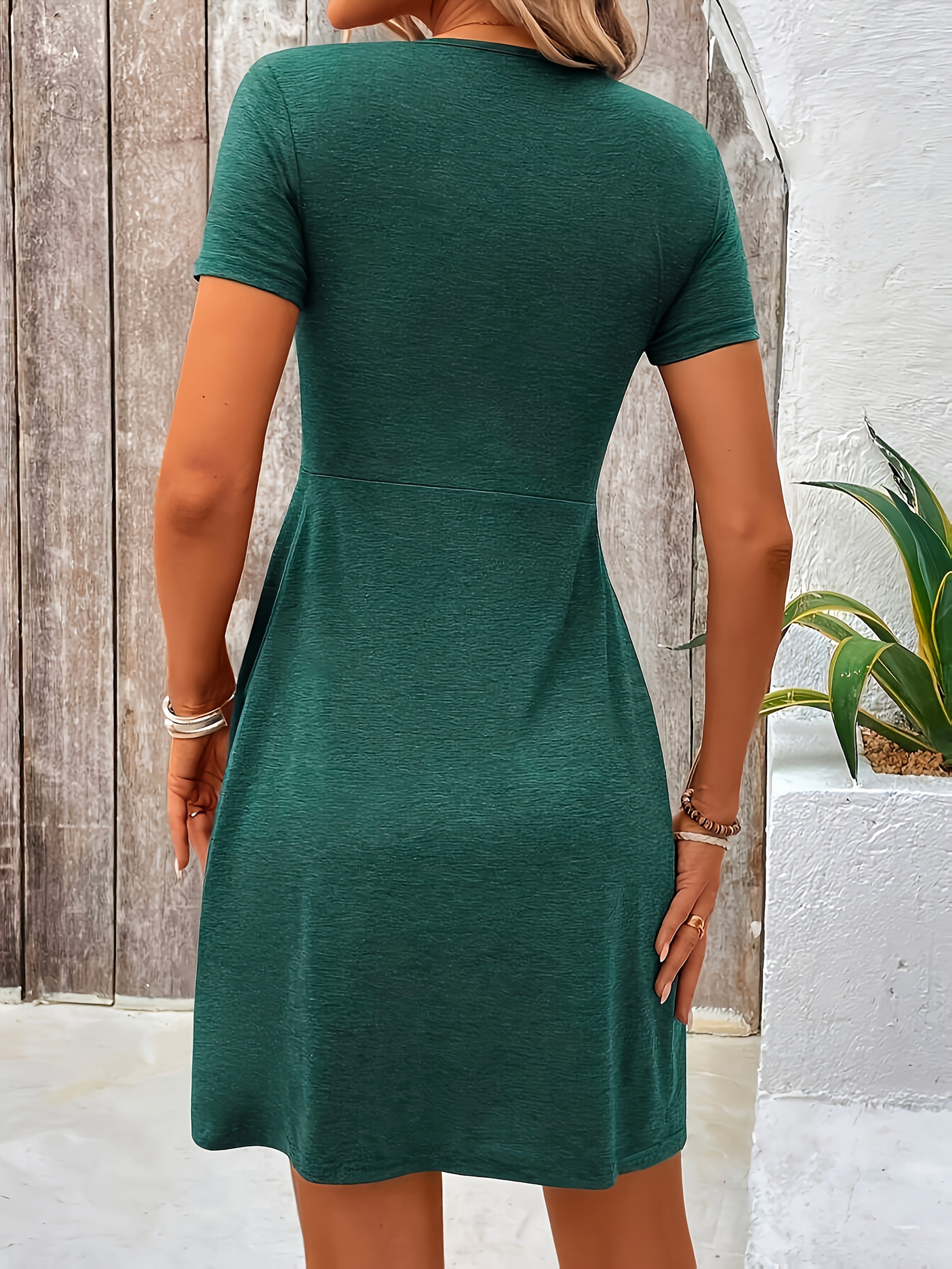 Green short-sleeve dress, back view, fitted waist and flared skirt