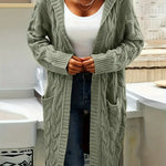 Mint green cable-knit long cardigan, open front, draped over denim