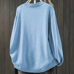 Light blue cardigan sweater with ribbed collar, cuffs, and rounded hem