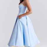 Light blue fitted corset dress with spaghetti straps and gathered flared midi skirt