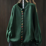 Green knit cardigan with round neckline, multicolor button-front placket and long sleeves.