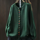 Green knit cardigan with round neckline, multicolor button-front placket and long sleeves.