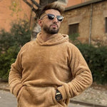Tan fleece hoodie pullover worn by a man, hood up and hands in the front pocket.