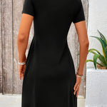 Black short-sleeve dress, back view, fitted waist and flared skirt