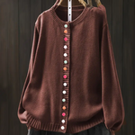 Rust-brown knit cardigan with round neckline and multicolor button-front placket.