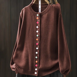 Rust-brown knit cardigan with round neckline and multicolor button-front placket.
