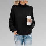 Black chunky knit sweater with ribbed turtleneck, long sleeves, and straight hem