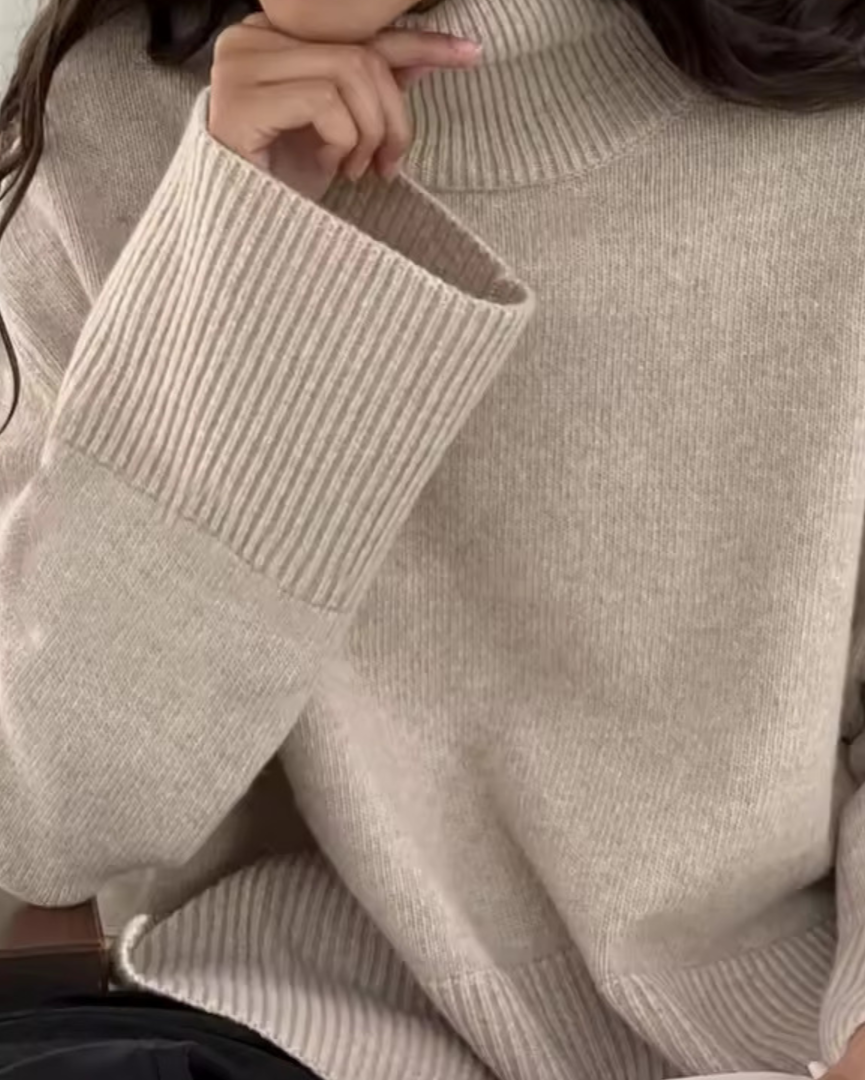 Cream knit turtleneck sweater with long sleeves, ribbed cuffs, and neckline