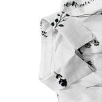 White dress sleeve detail with dark floral pattern
