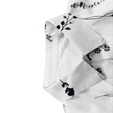 White dress sleeve detail with dark floral pattern