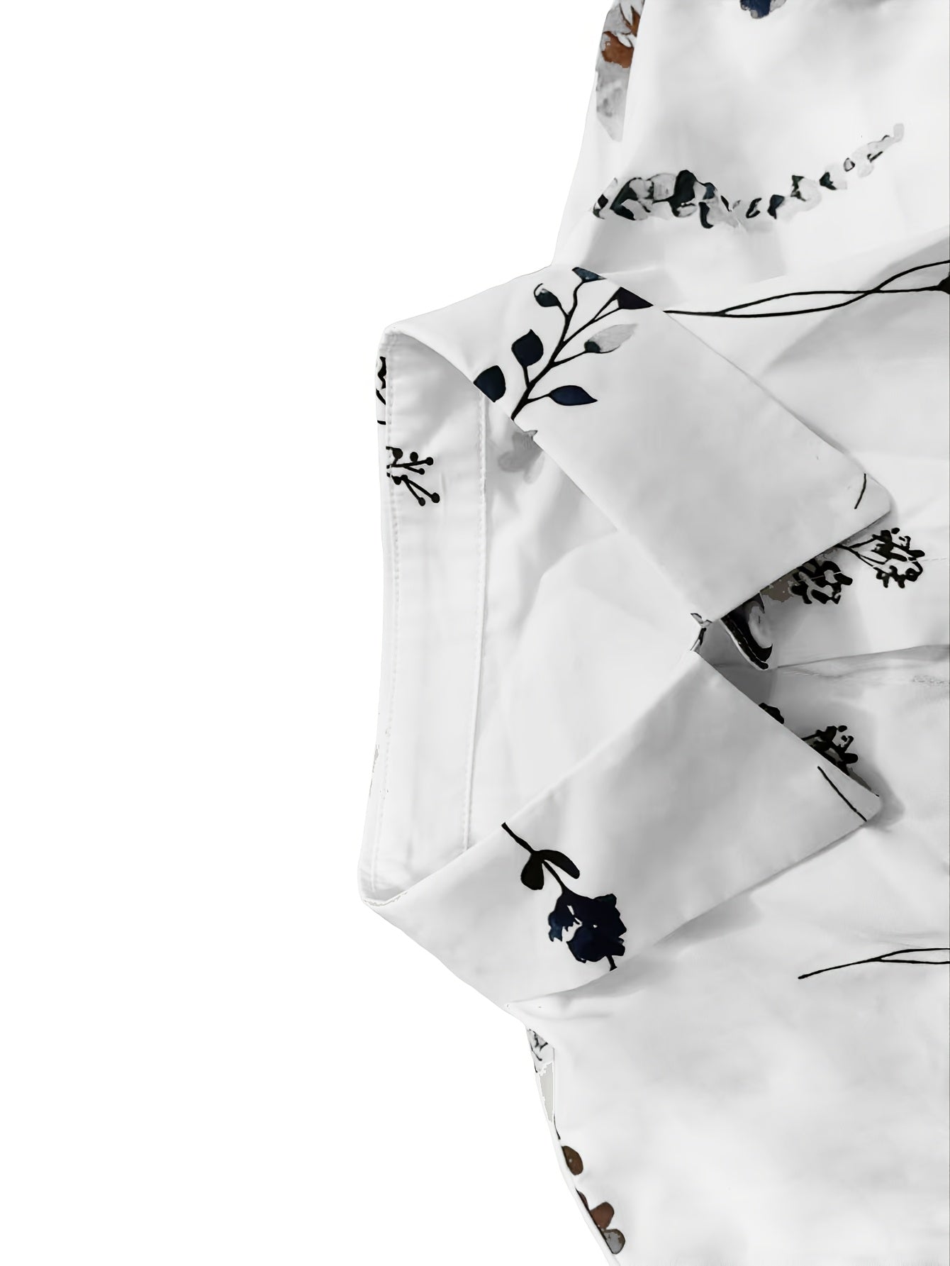 White dress sleeve detail with dark floral pattern