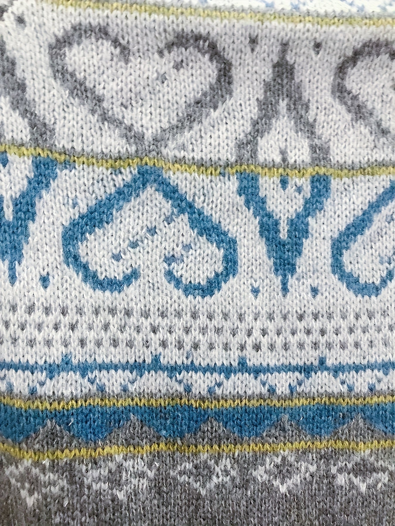 Fair isle yoke sweater close-up with blue and gray motifs and ribbed stripes