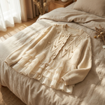 Cream cardigan laid flat, showing textured front and tiered layered ruffle hem