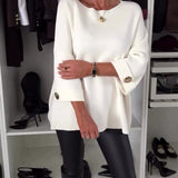White knit pullover with round neckline and button detail on sleeve cuffs