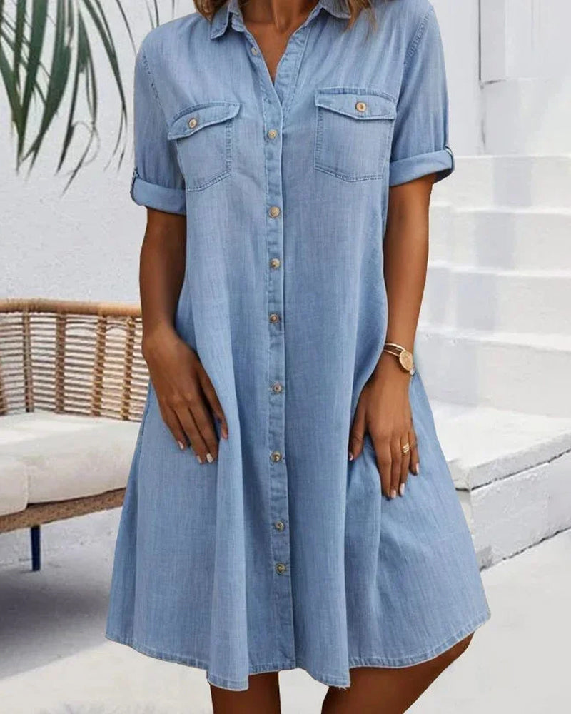 Light blue denim shirt dress with short sleeves, button front, and chest pockets